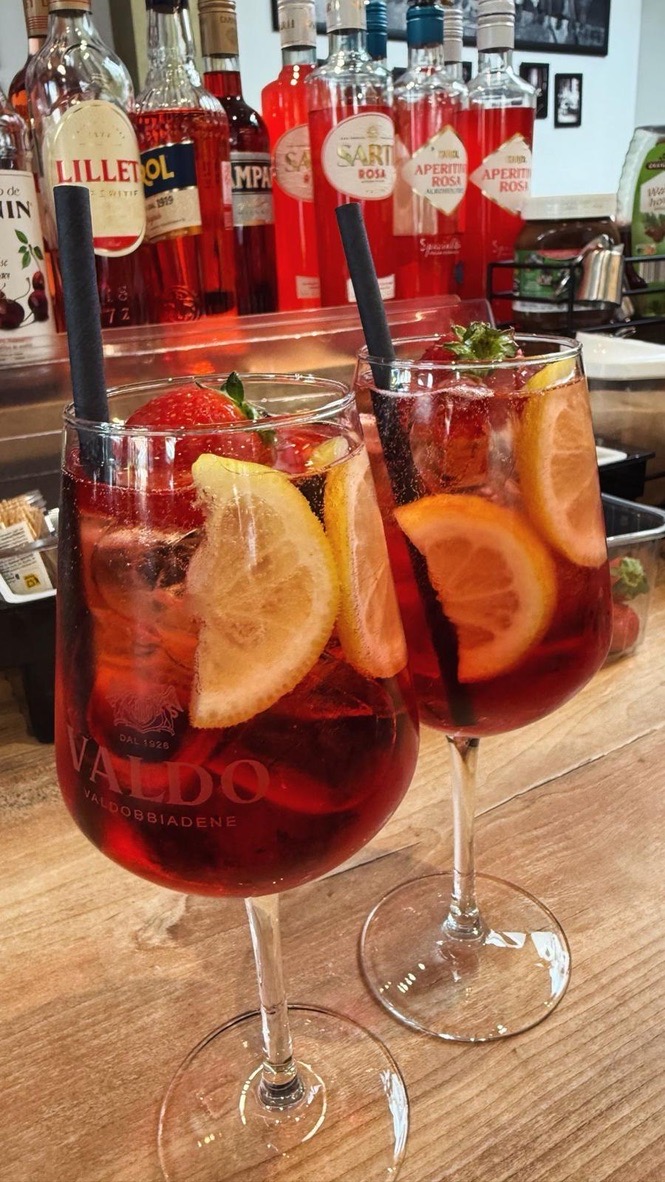 Zwei rote Spritz mit Zitrone und Erdbeere an der Bar